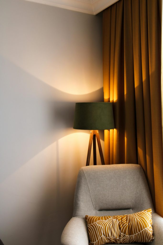 A warm table lamp lighting a cozy corner of a living room