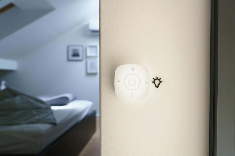 A wall-mounted smart lighting control panel in a modern bedroom