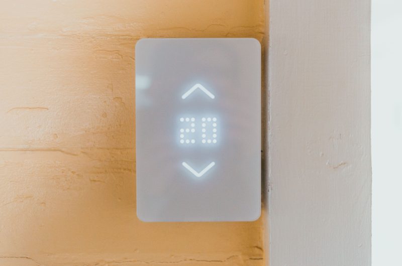 Do smart thermostats save money — a modern smart thermostat installed on a wall