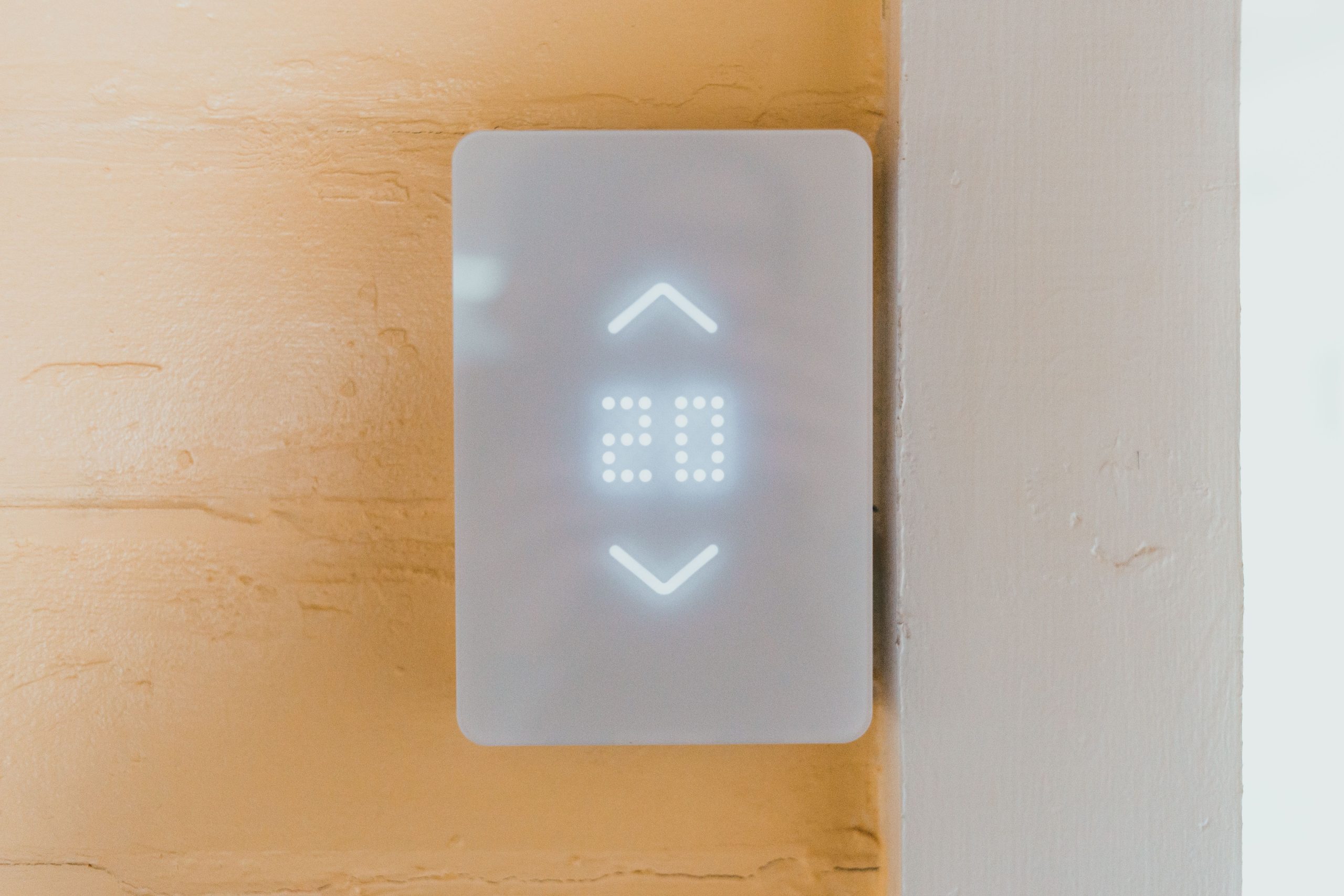Do smart thermostats save money — a modern smart thermostat installed on a wall