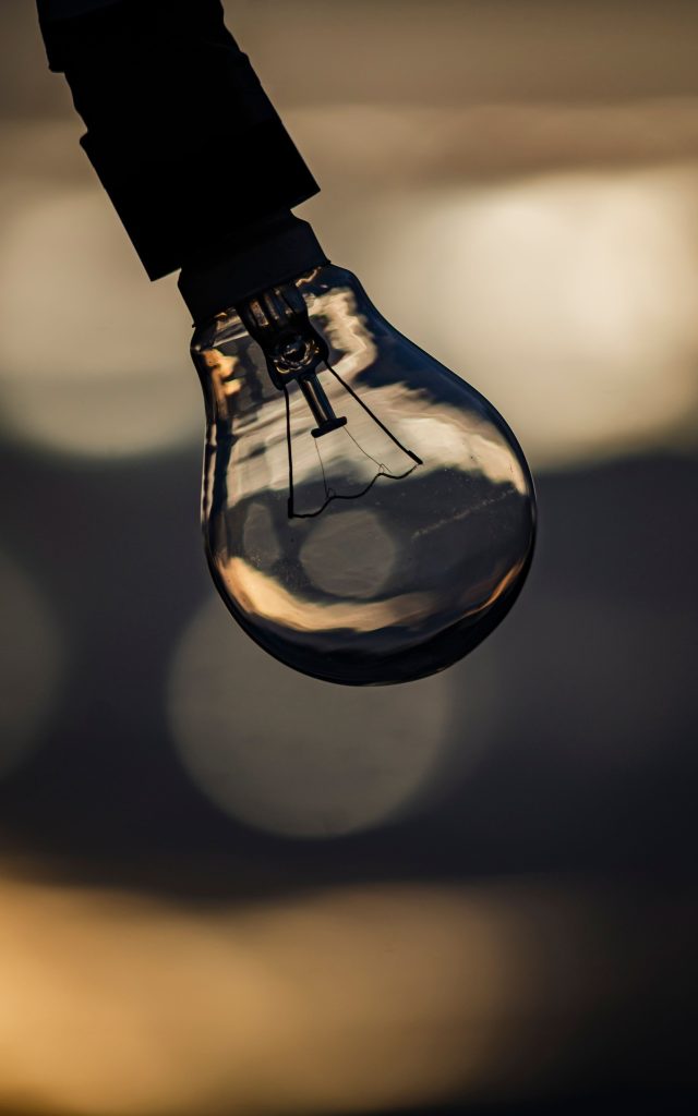 A light bulb hanging against a warm background, representing smart bulbs