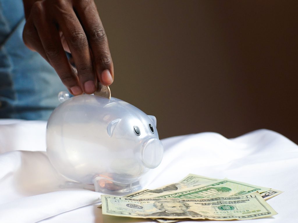 A piggy bank with dollar bills representing the cost and savings of smart home devices